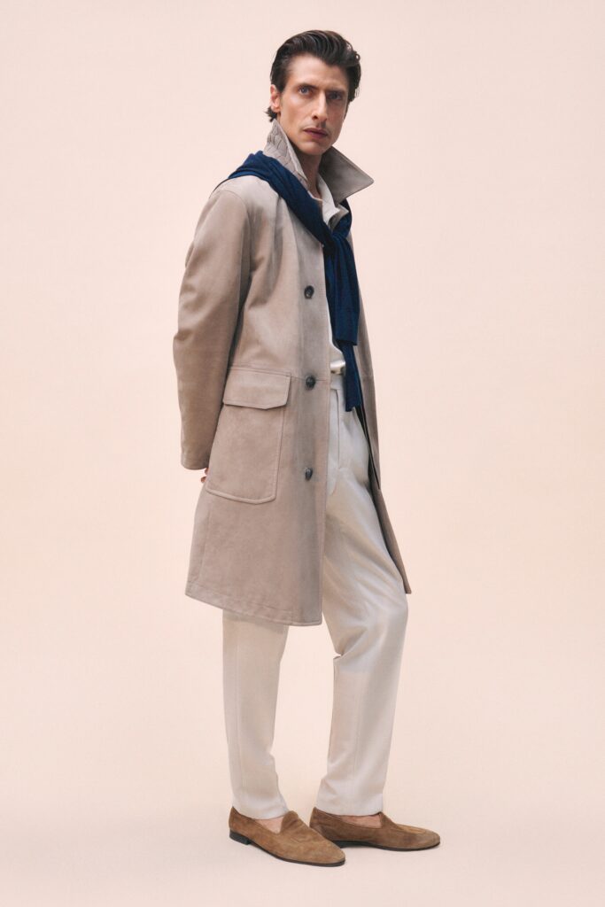 A relaxed beige coat paired with white pants, featuring a collared design and buttoned front.