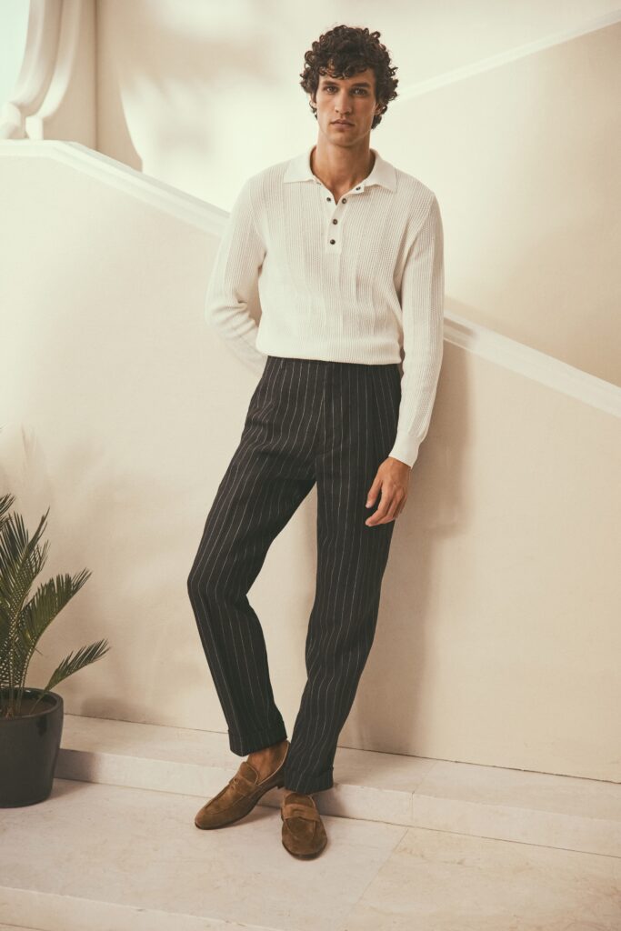 A fitted white long-sleeve collared shirt paired with black striped pants.