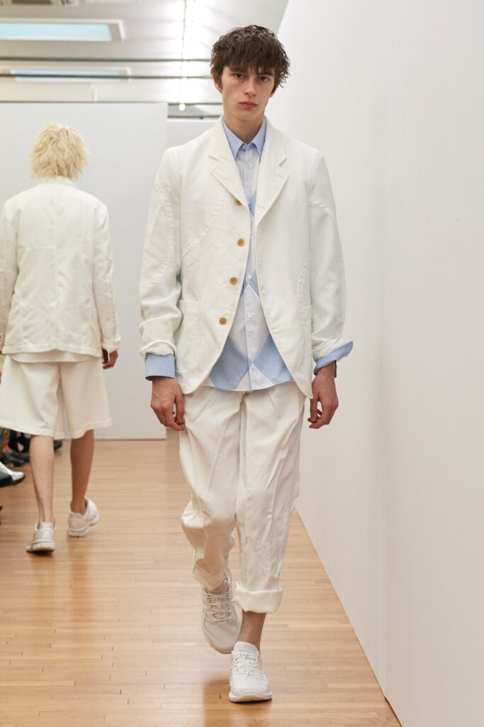 A relaxed white cotton suit featuring a long-sleeve collared shirt and buttoned jacket.