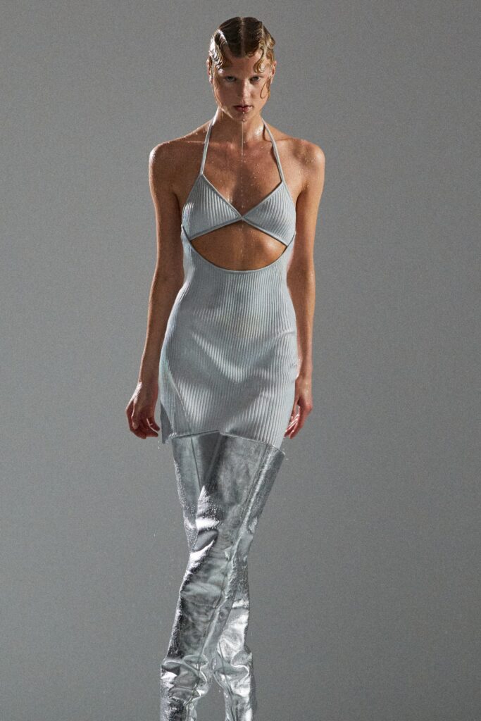 A fitted silver sleeveless dress with a halter neckline and cutout detail.