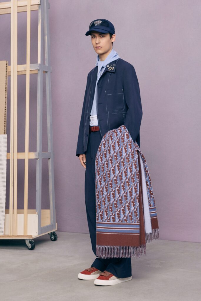 A tailored blue jacket paired with brown pants, featuring a modern design and long sleeves.