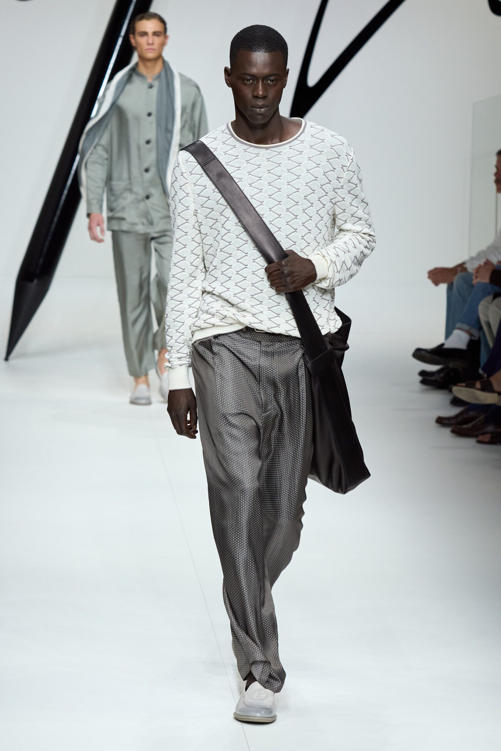 A relaxed white long-sleeve striped sweater paired with wide-leg gray pants.