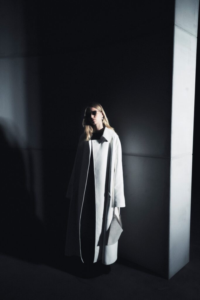 An oversized white coat with long sleeves and a collared design.