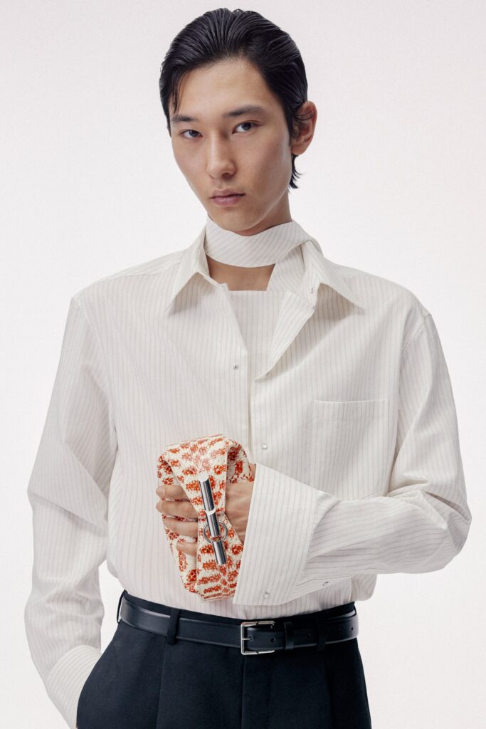 A fitted white striped shirt with long sleeves and a collar, paired with black fitted pants.
