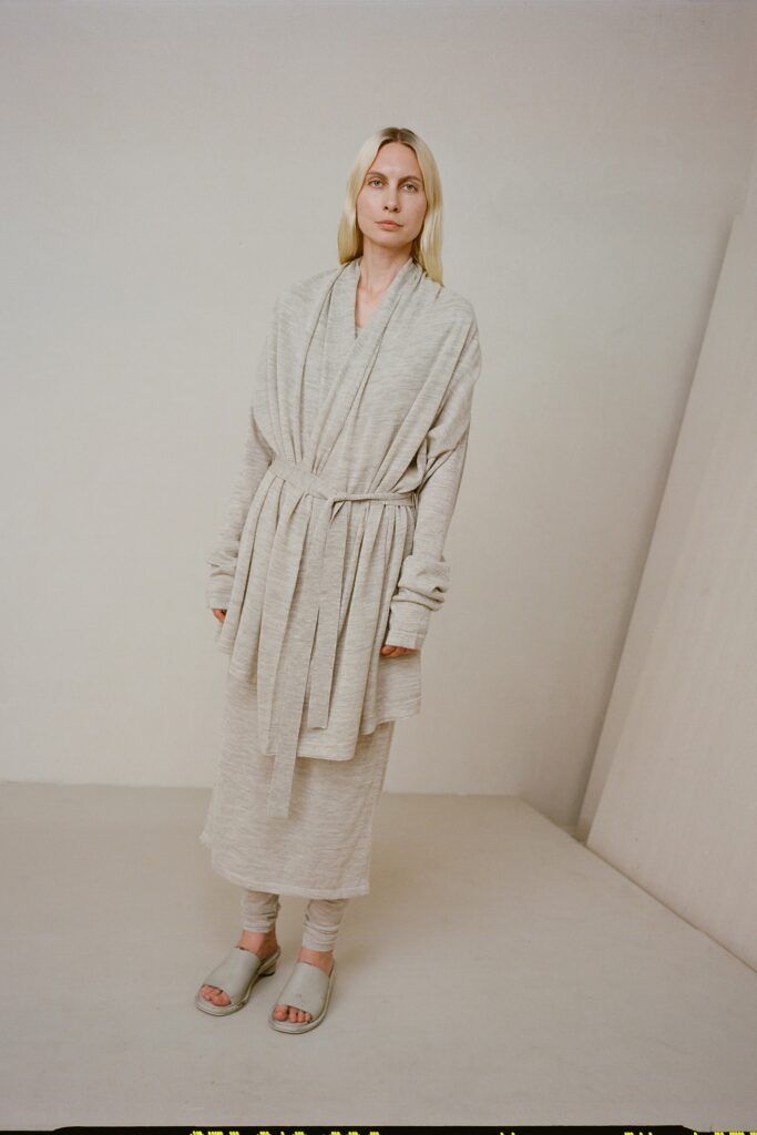 A relaxed beige coat dress with long sleeves and a belted design.