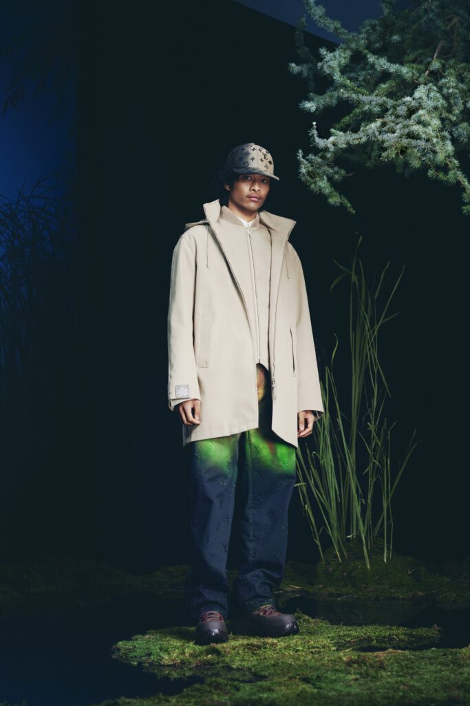 A relaxed beige cotton coat paired with black pants featuring a long-sleeve and collared design.
