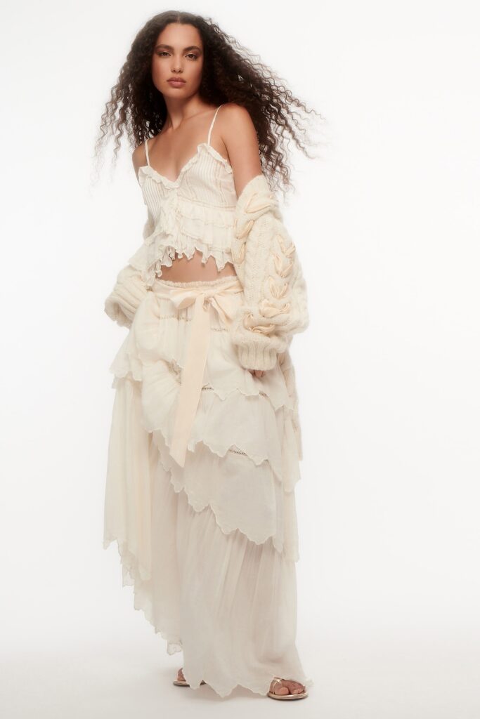 A relaxed white tiered dress with ruffled details and a sleeveless V-neck design.