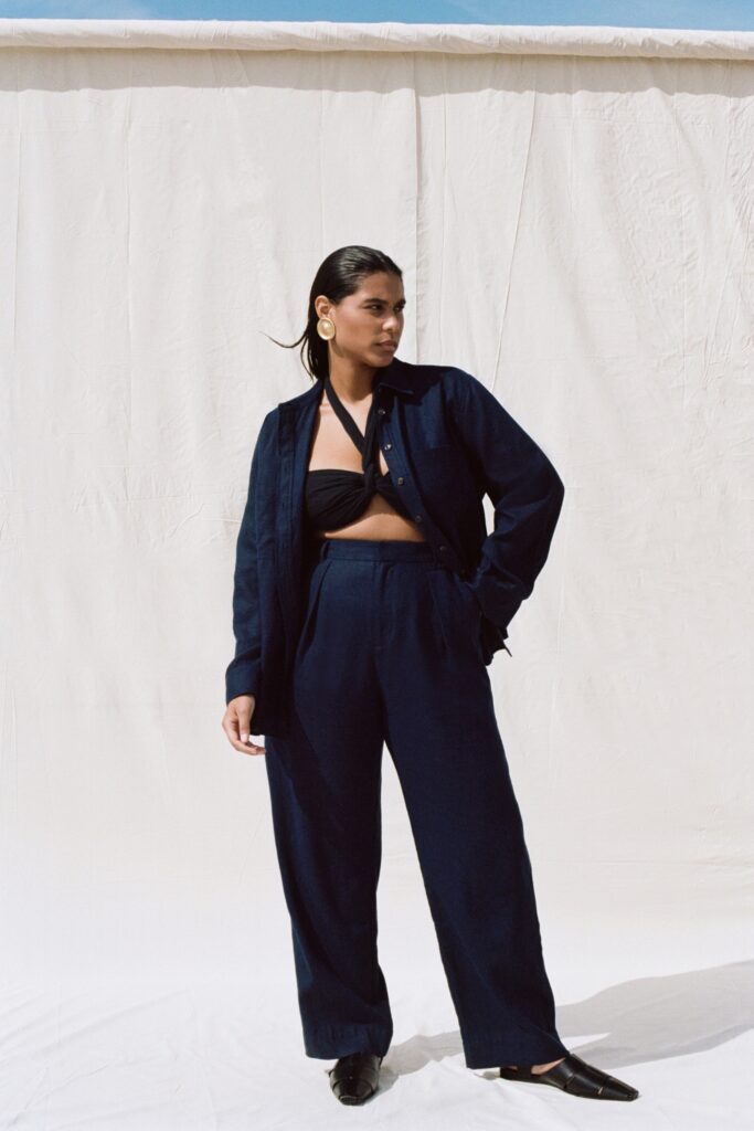 A relaxed navy cotton shirt with long sleeves and collared design paired with straight-leg pants.