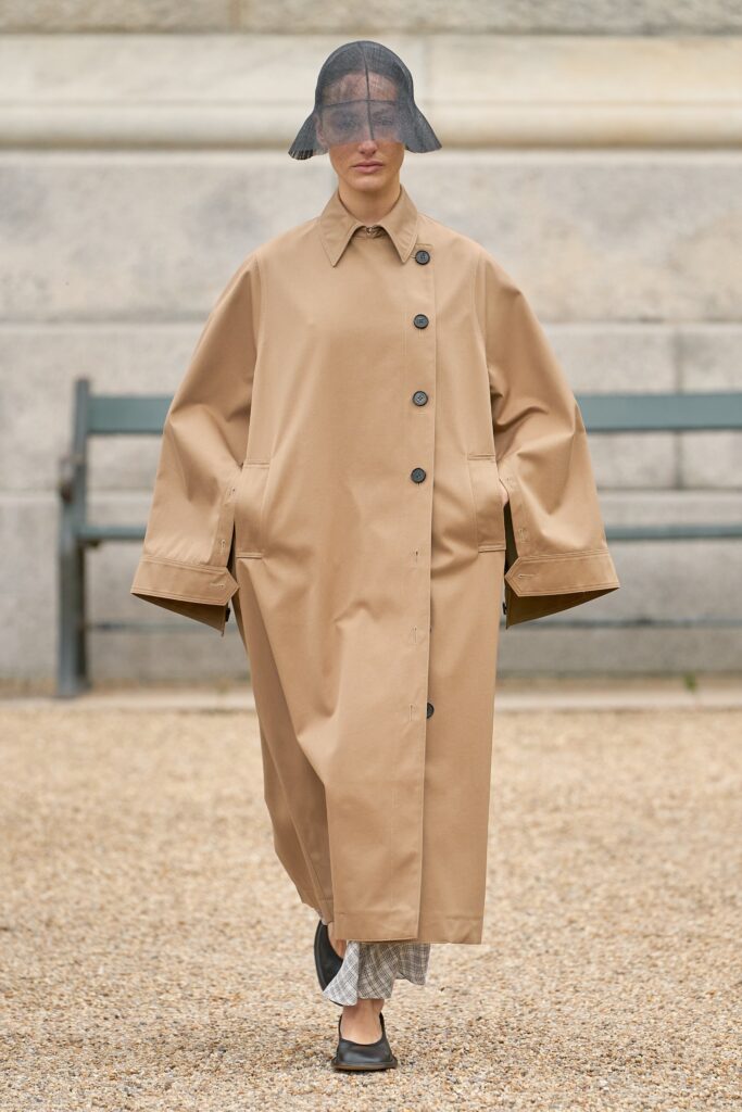 An oversized beige coat with long sleeves and a collared design, featuring button details.