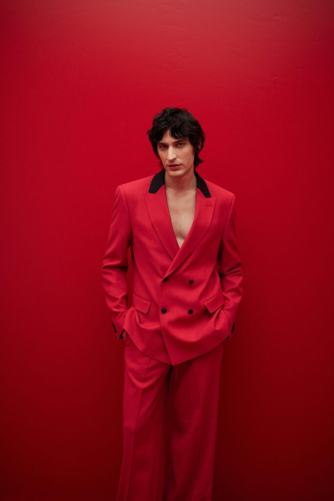 A tailored red double-breasted suit with a collared neckline and long sleeves.
