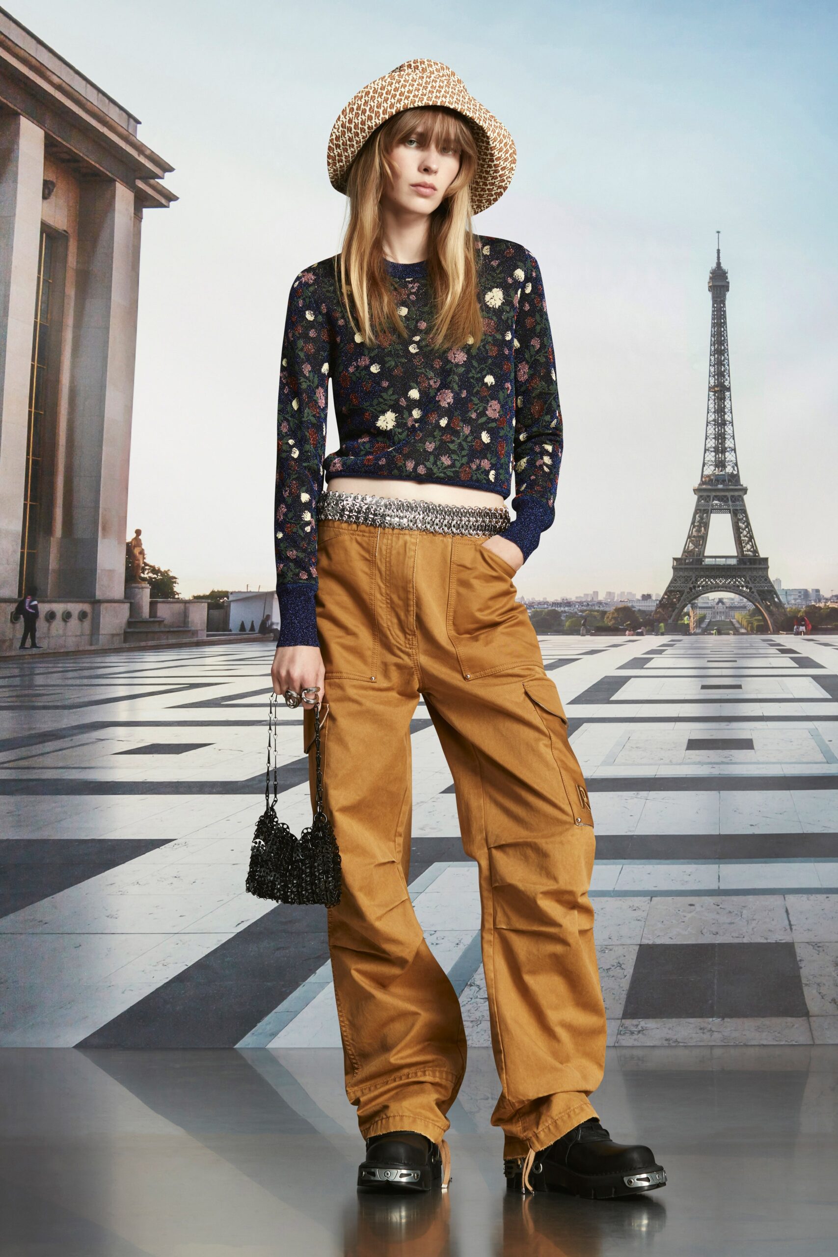 A relaxed navy floral long-sleeve sweater paired with wide-leg brown pants.