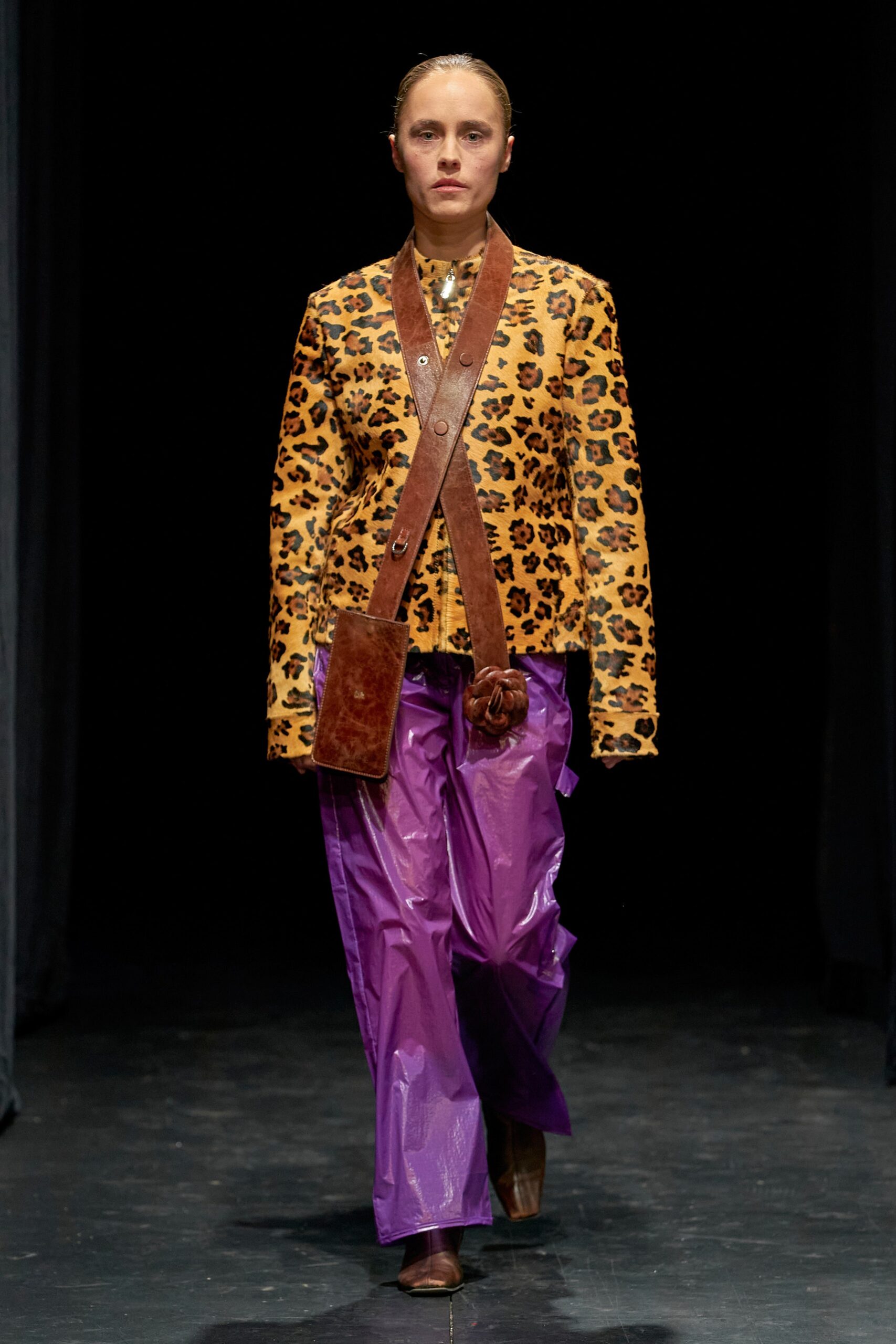 A relaxed-fit brown printed jacket with long sleeves paired with wide-leg purple pants.