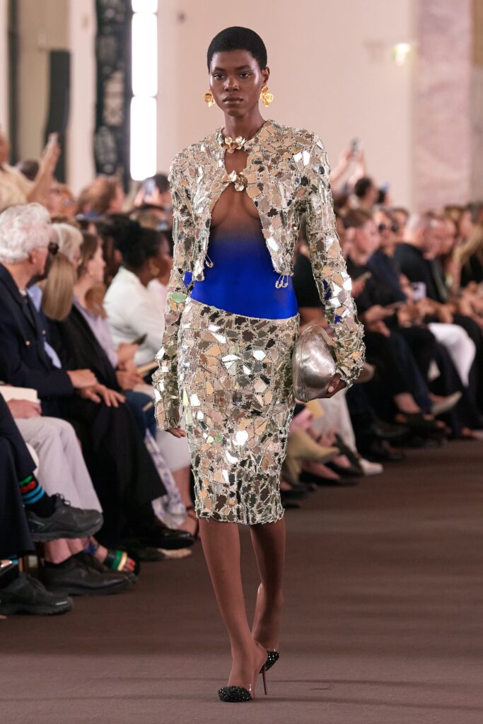 A fitted silver sequin jacket paired with a blue pencil skirt, creating a striking runway look.
