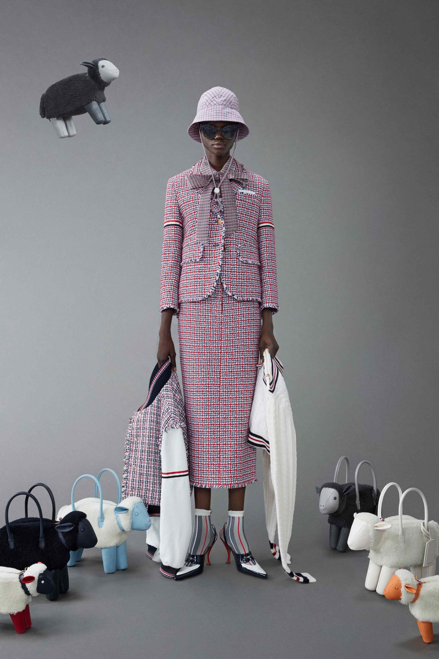 A tailored pink tweed blazer with a collared neckline paired with a pencil skirt.