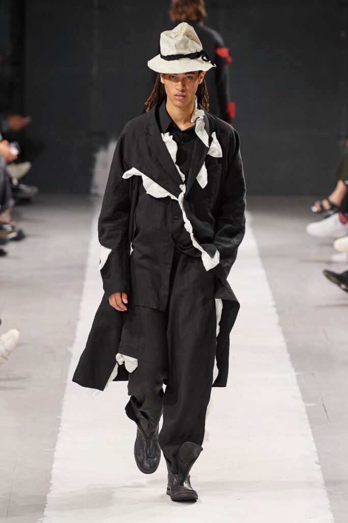 A relaxed black and white layered coat with long sleeves and collared design paired with matching pants.