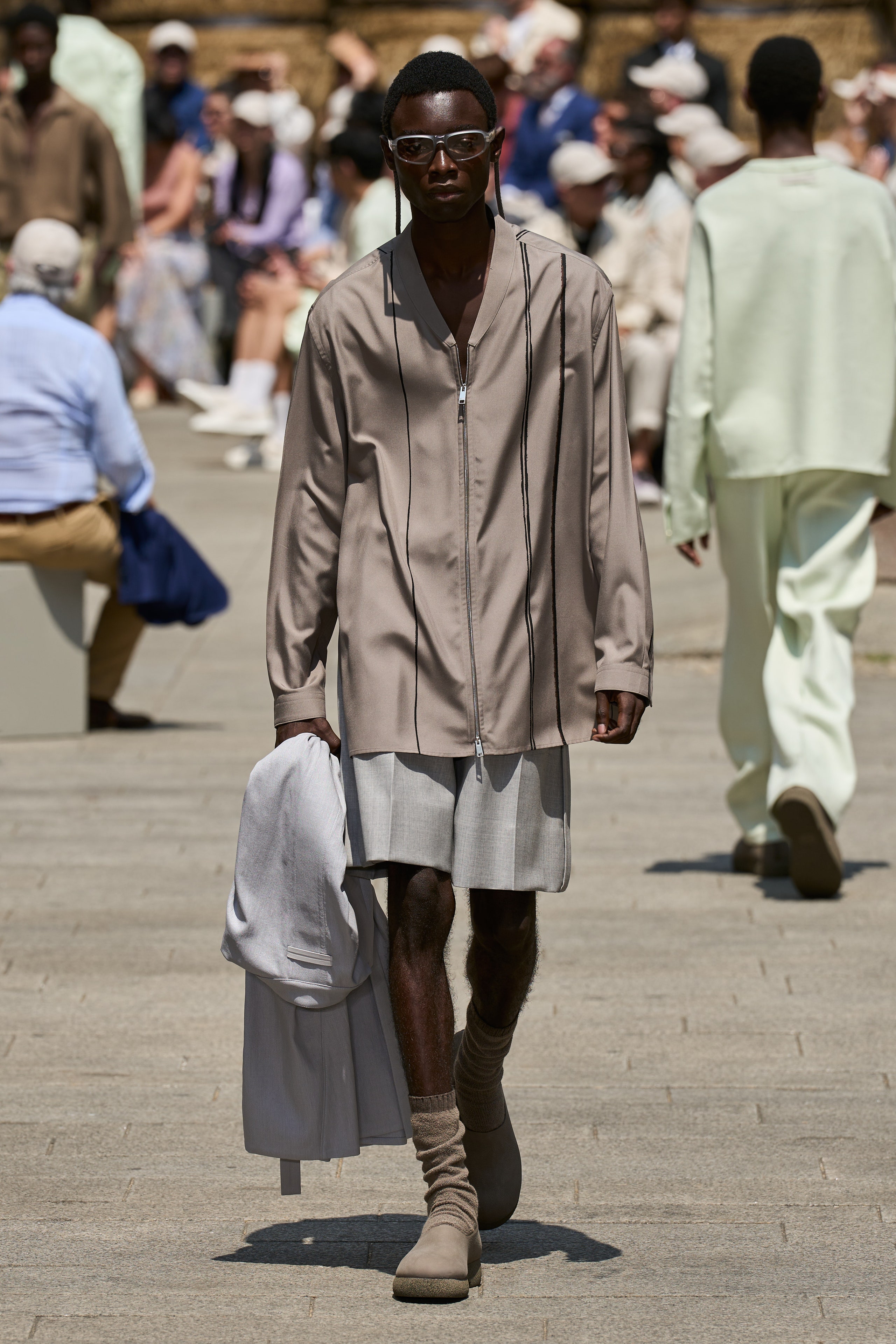 A relaxed beige long-sleeve collared shirt paired with an asymmetric skirt.