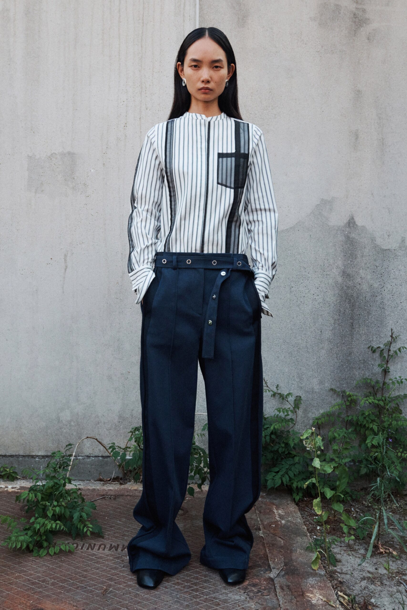 A relaxed fit long-sleeve striped white shirt paired with wide-leg blue pants.