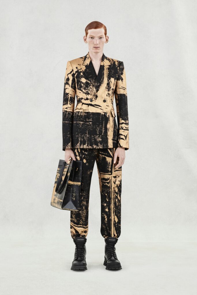 A fitted black and gold printed suit with a collared long-sleeve design.