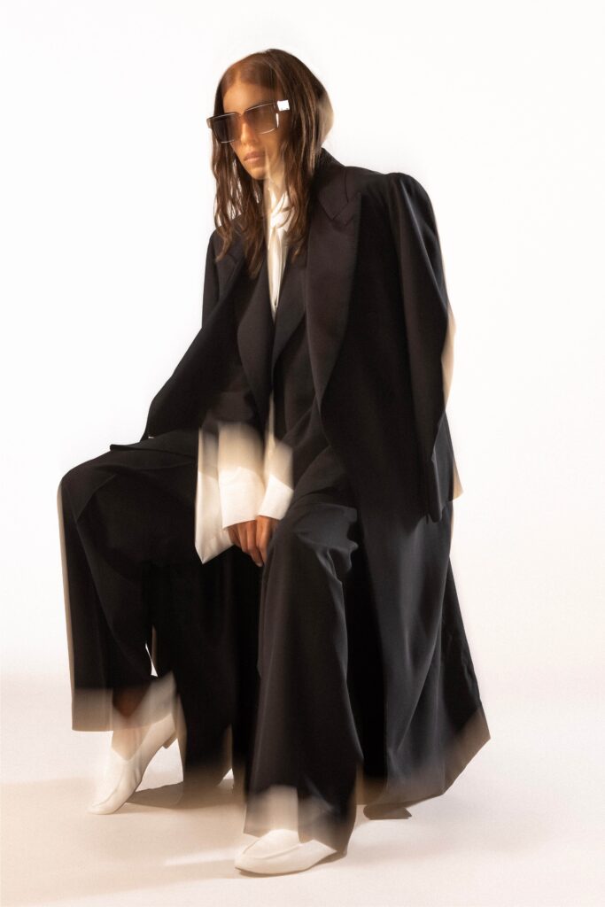 A relaxed black jacket with long sleeves and a collared design, paired with matching pants.