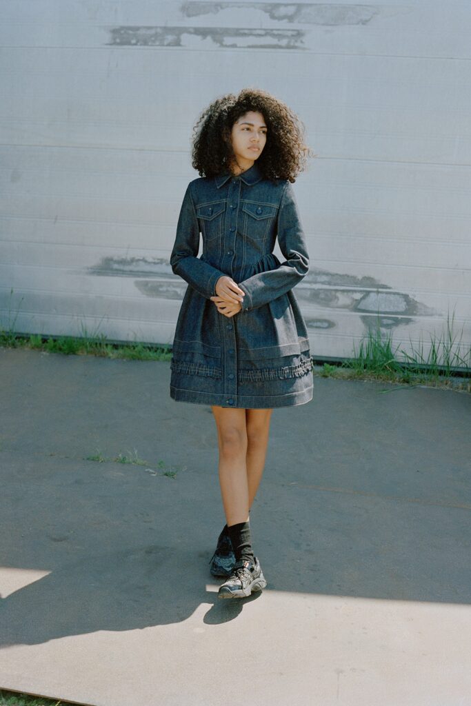 A fitted blue denim dress with long sleeves, a collared neckline, and an A-line silhouette.