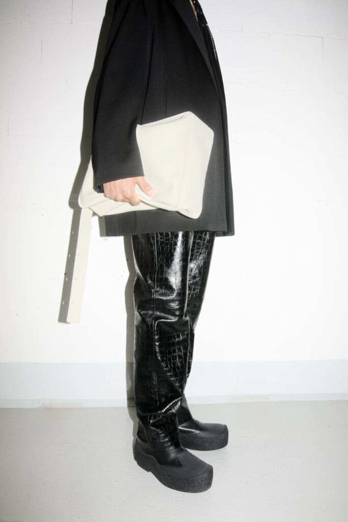 A fitted black leather jacket paired with straight-leg pants, creating a sleek silhouette.