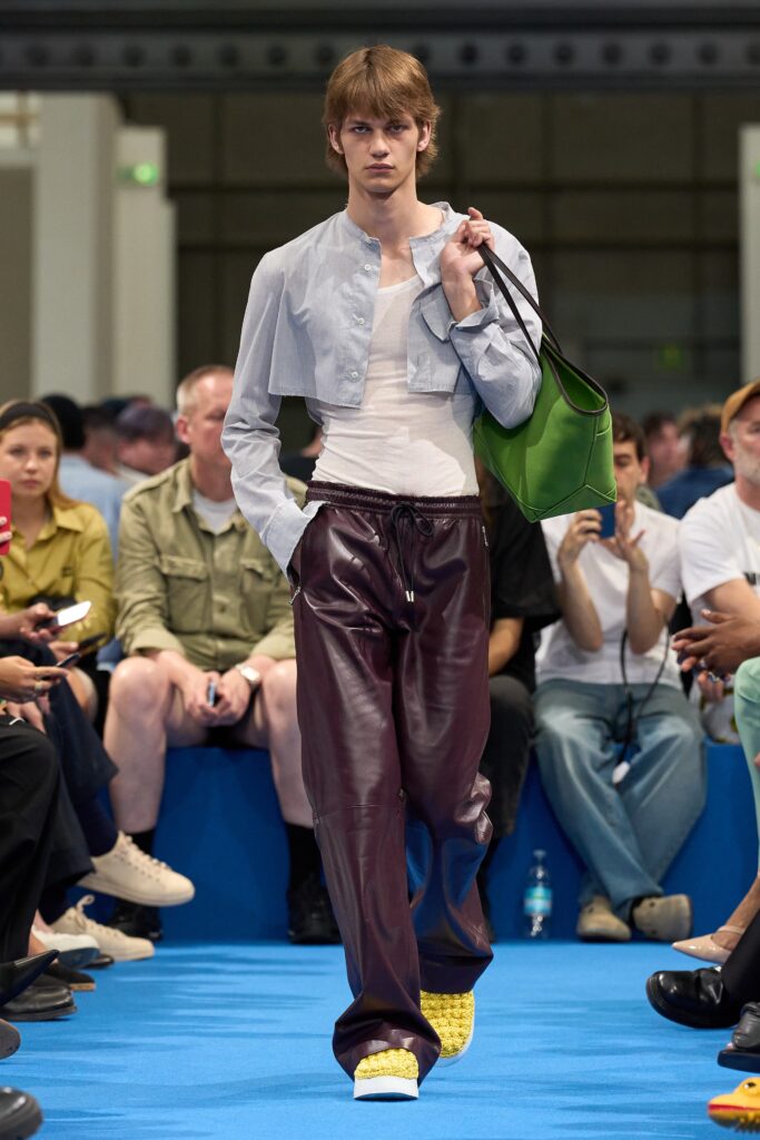 A relaxed gray long-sleeve collared shirt paired with burgundy straight-leg pants.