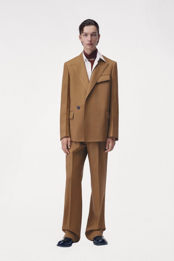 A tailored brown wool suit featuring a long-sleeve collared shirt and buttoned details.
