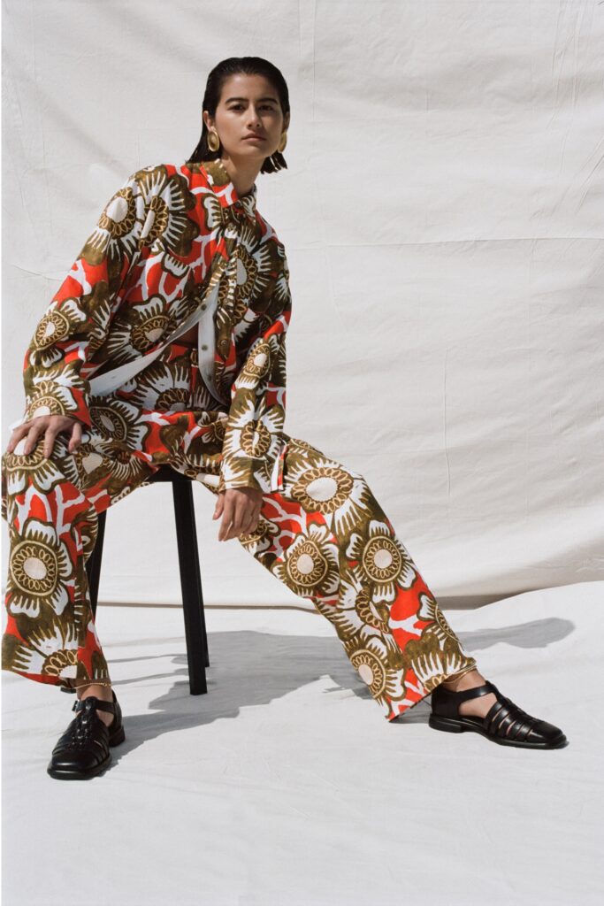 A relaxed fit long-sleeve collared shirt paired with printed pants in red and brown.
