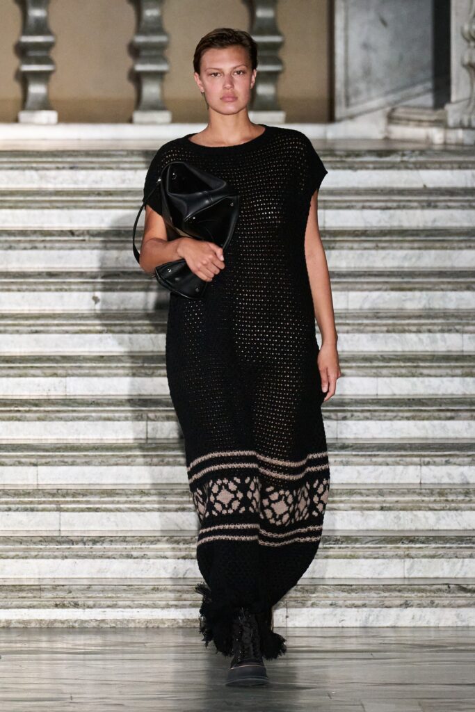 A relaxed black sleeveless dress with a high neckline and layered design detail.
