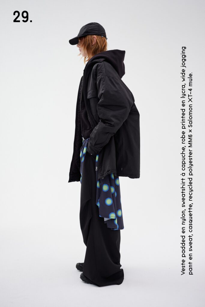 A relaxed black jacket with long sleeves and layered pants for a contemporary look.