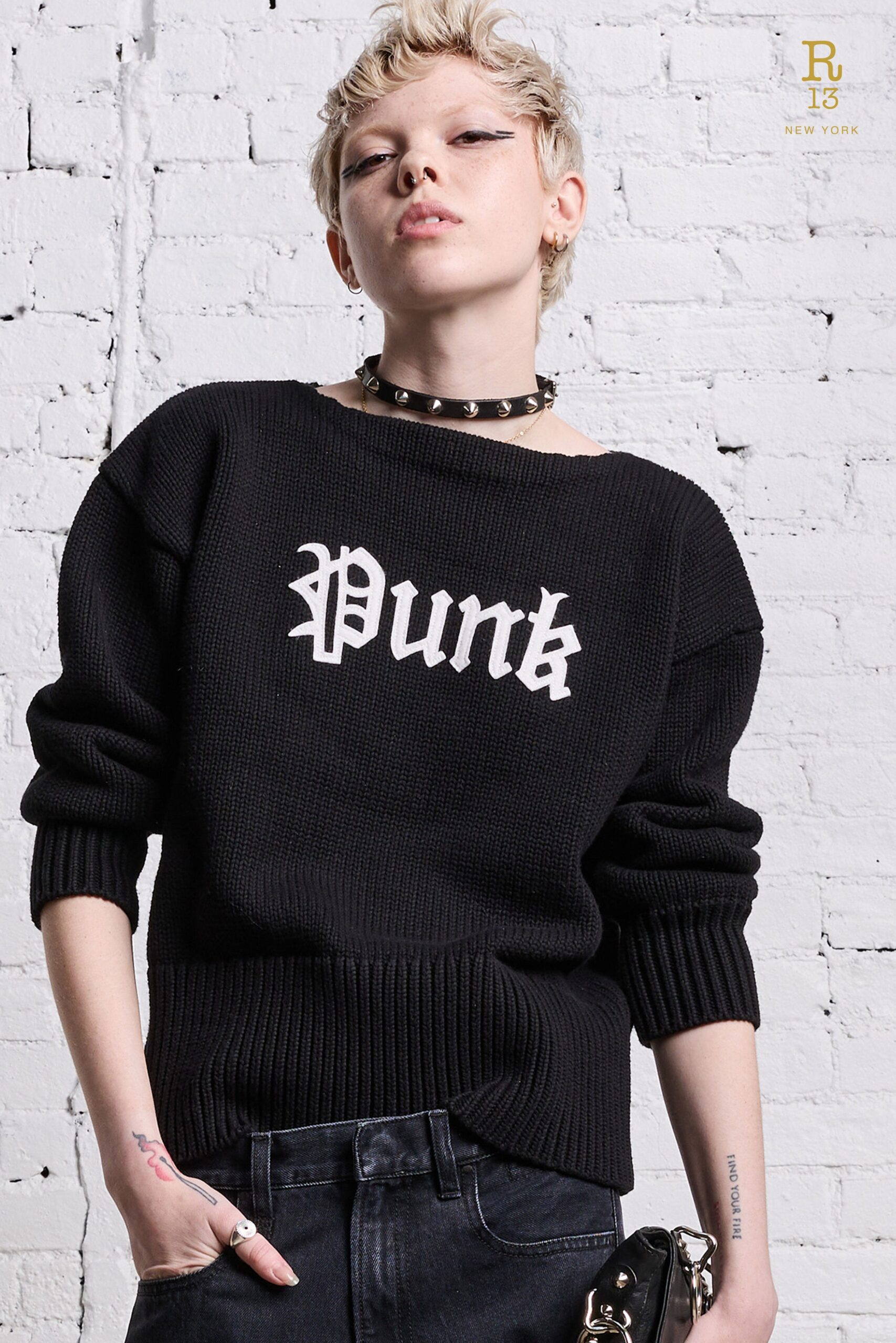 An oversized black cotton sweater with long sleeves and a printed design.