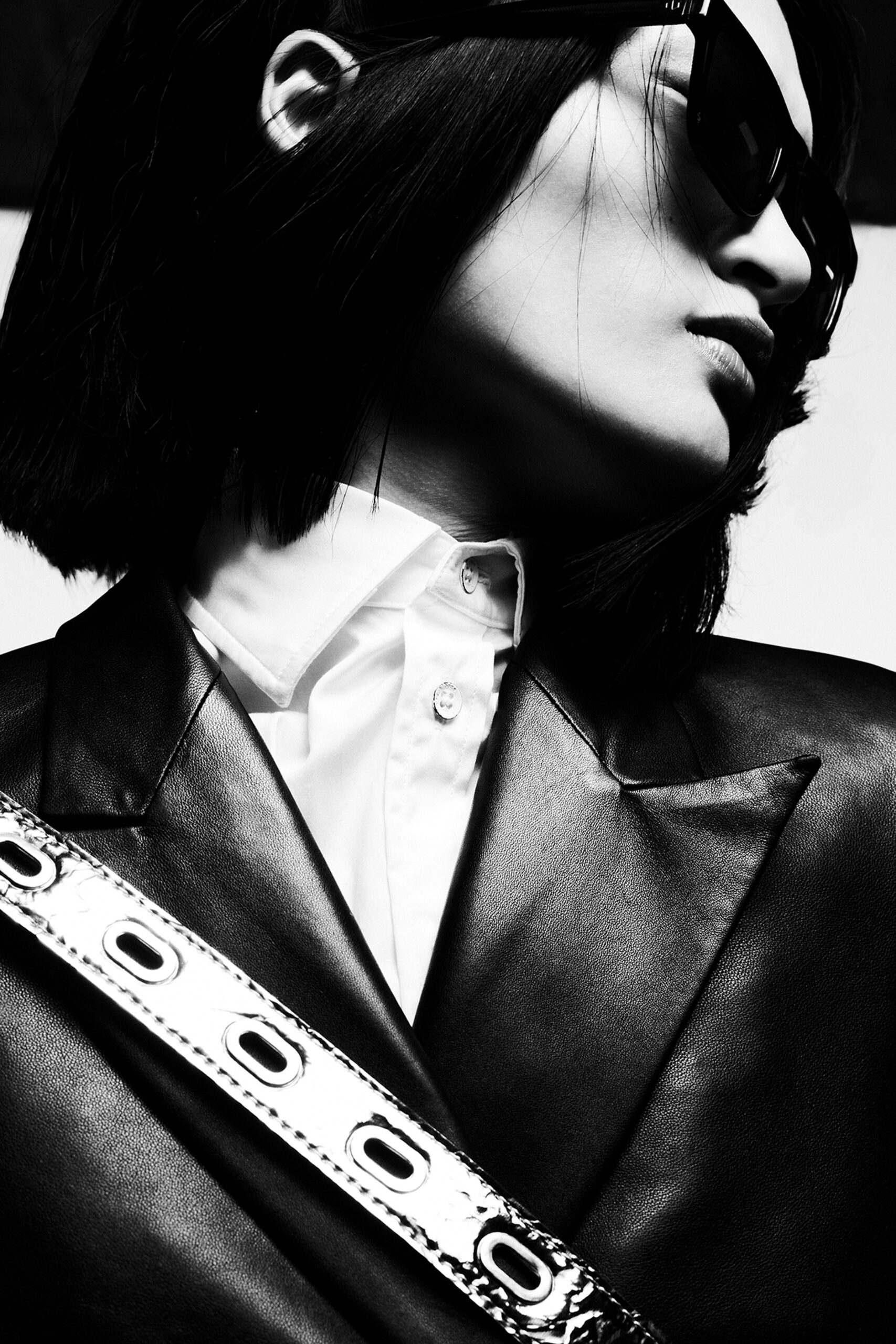 A fitted black leather blazer with a collared neckline and structured design.