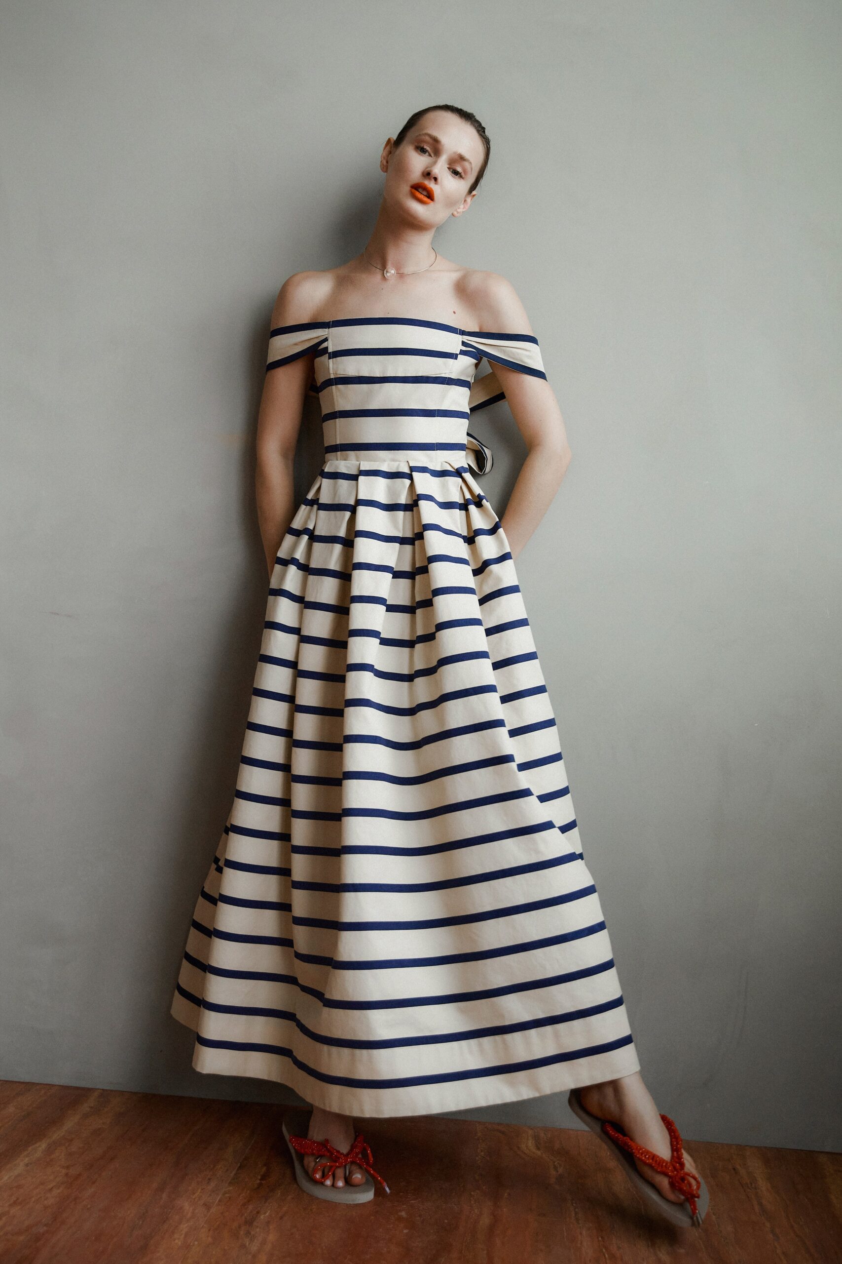 A fitted off-shoulder dress with blue stripes and an A-line silhouette.