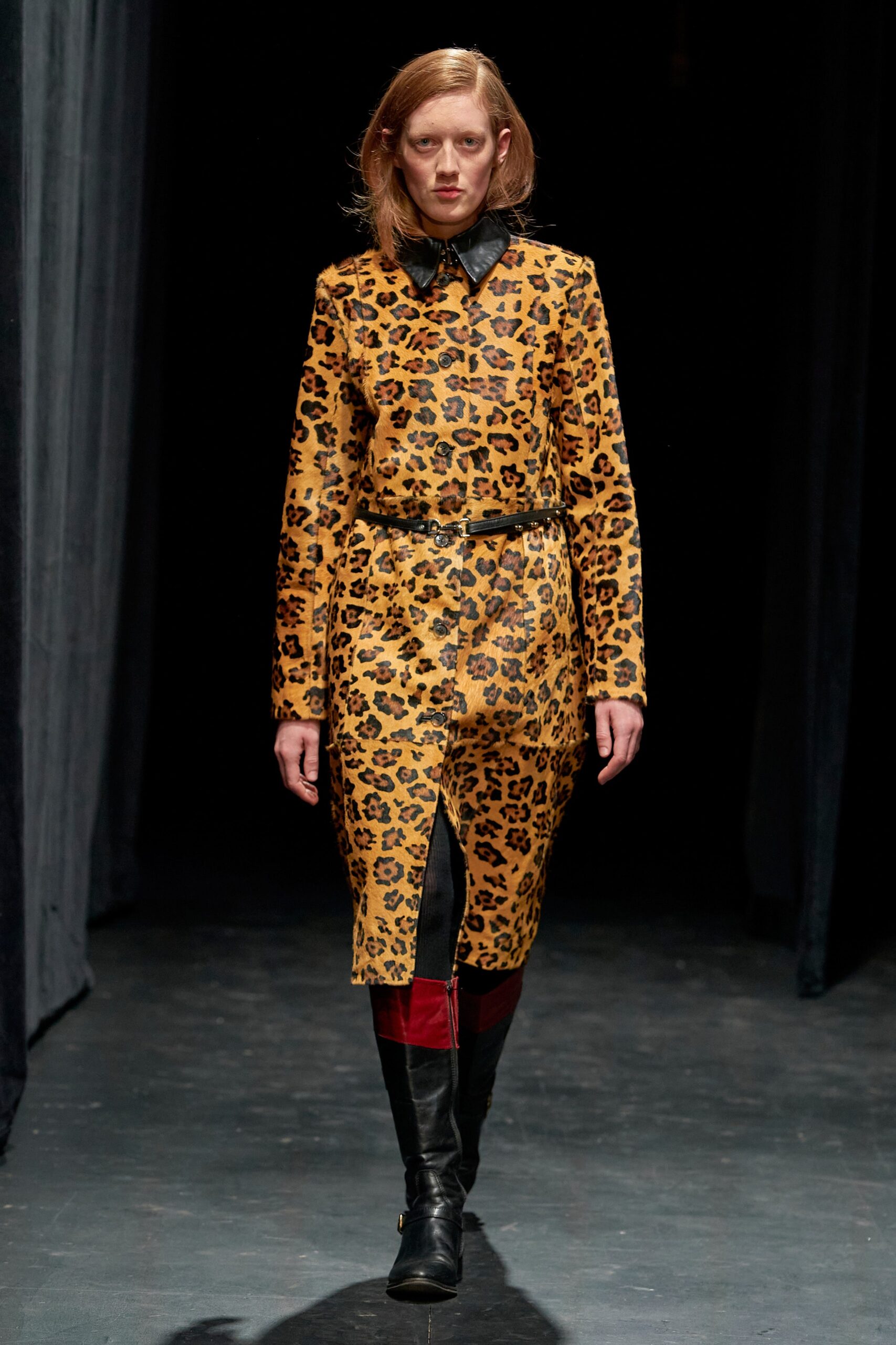 A fitted yellow and black printed dress with long sleeves and a collared neckline.