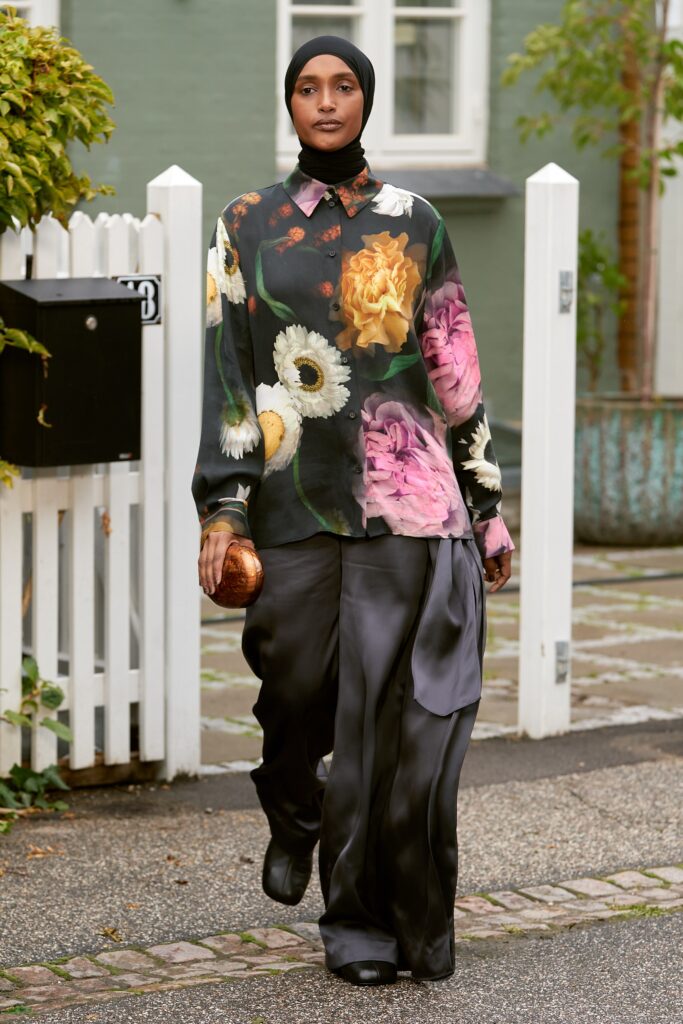 A relaxed-fit multicolor floral shirt with long sleeves paired with black silk pants.