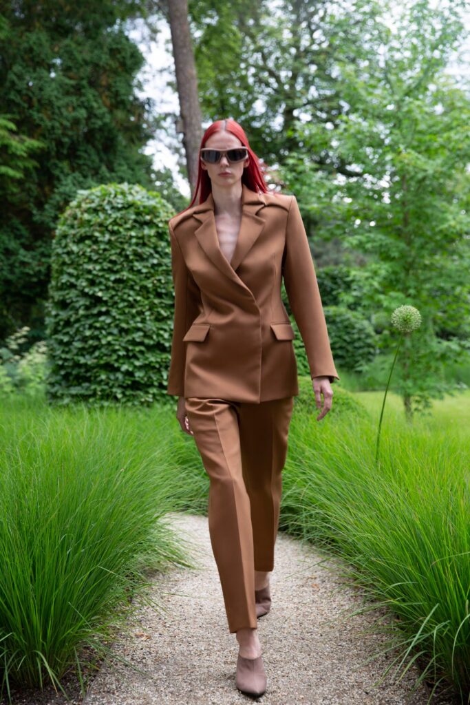 A tailored brown suit featuring a collared long-sleeve jacket and matching trousers.