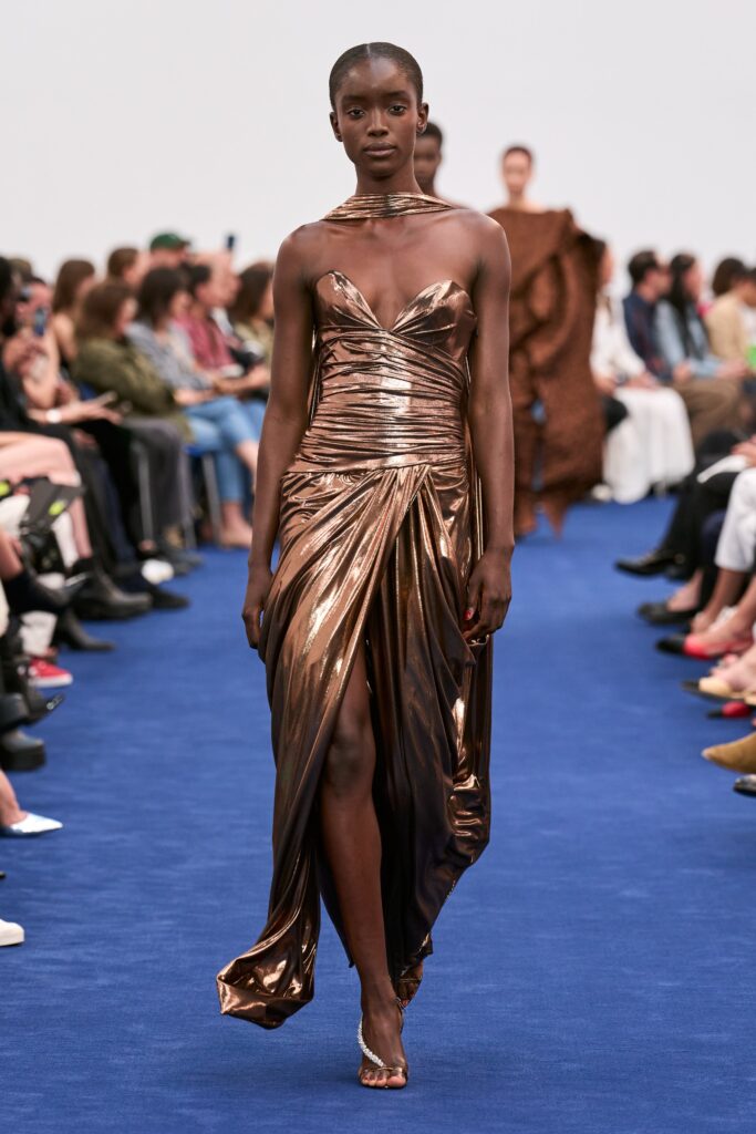 A fitted brown silk sleeveless dress with a V-neckline and a thigh-high slit.