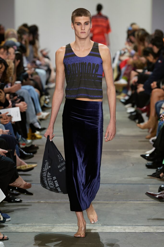 A fitted black cotton sleeveless top paired with a high-waisted purple velvet skirt.