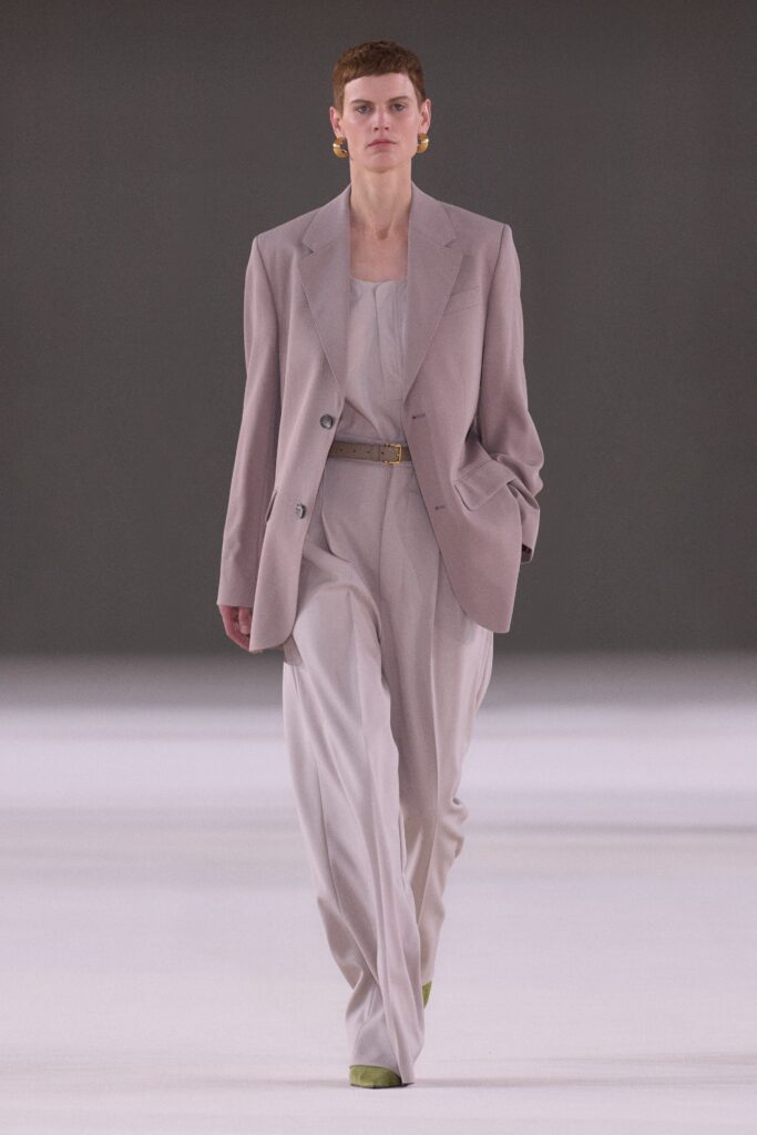 A relaxed beige blazer paired with straight-leg pants, featuring a collared neckline.