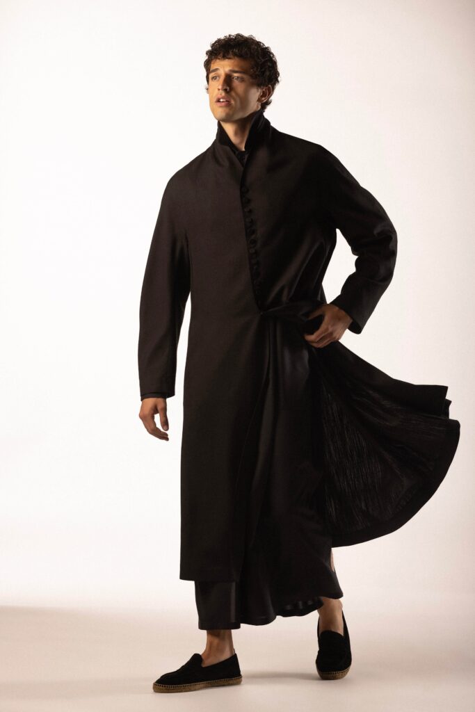 A relaxed black silk coat with long sleeves and an asymmetric design.