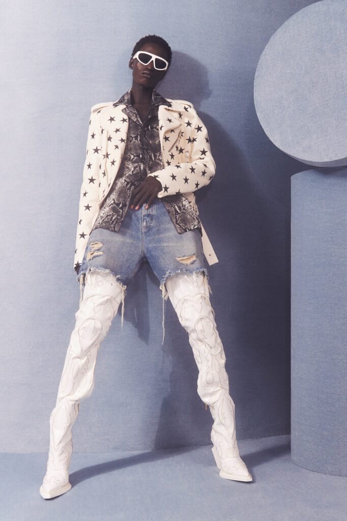 An oversized white jacket paired with distressed blue denim shorts, creating a bold fashion statement.