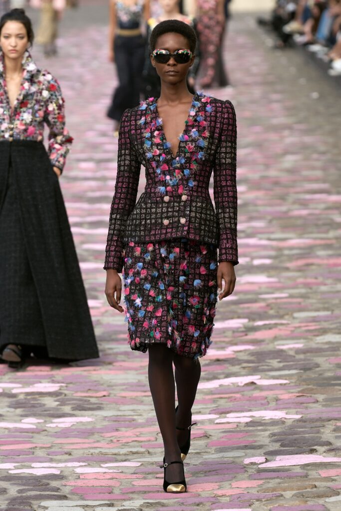 A fitted multicolor blazer with a V-neck and long sleeves paired with a flared skirt.
