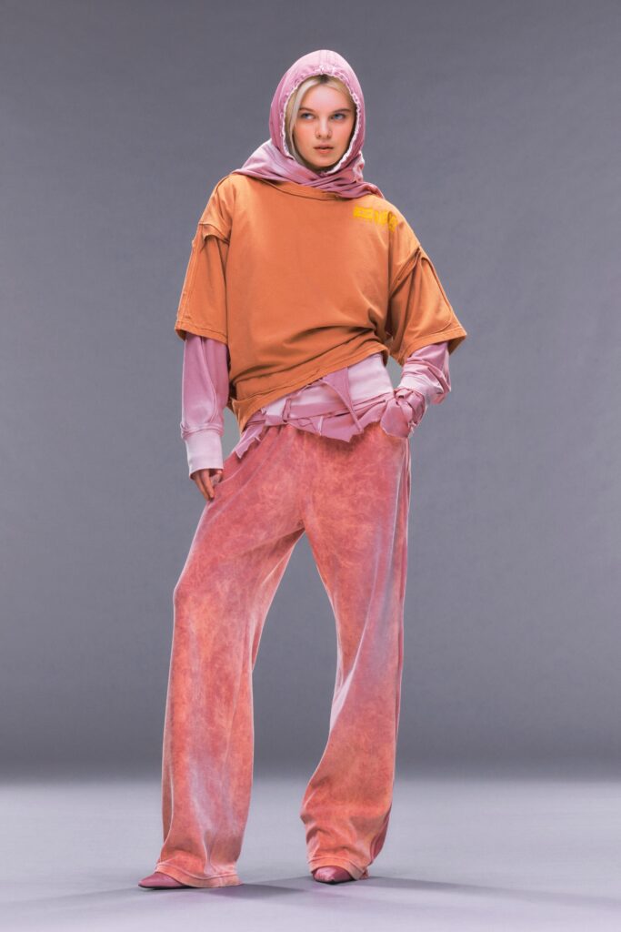 A relaxed orange top paired with pink pants, featuring a layered design.