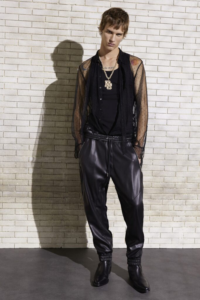 A relaxed black silk long-sleeve shirt with a collared design paired with black leather pants.