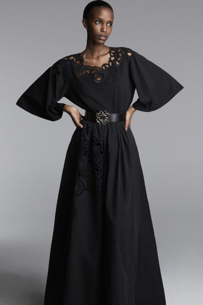 A relaxed black long-sleeve dress featuring intricate embroidery and a tiered design.
