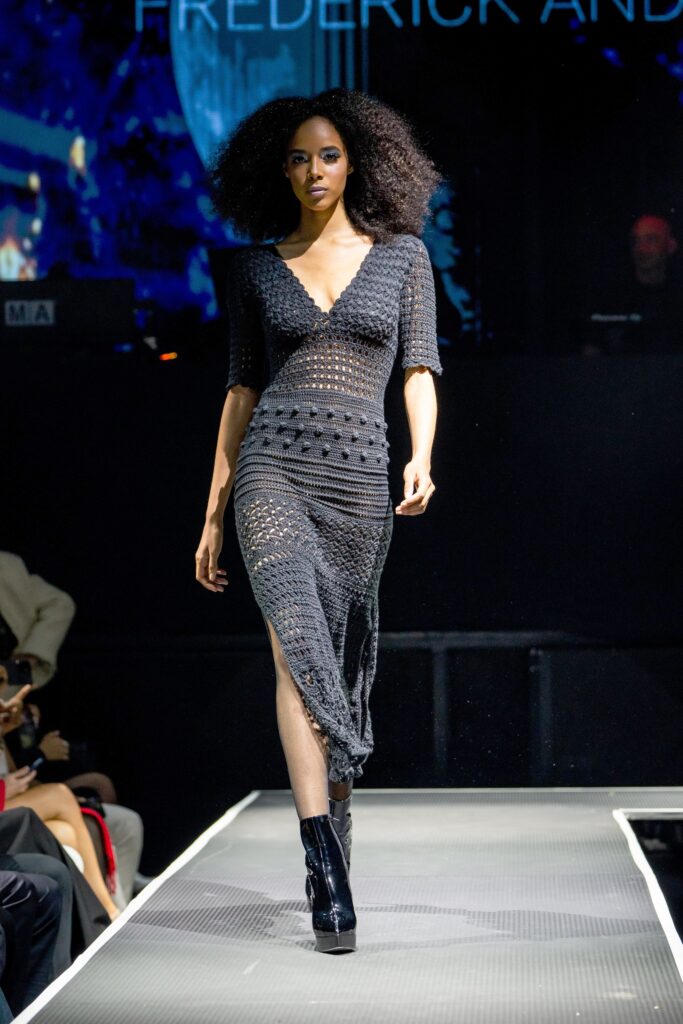 A fitted black knit dress with a V-neckline, short sleeves, and a side slit.