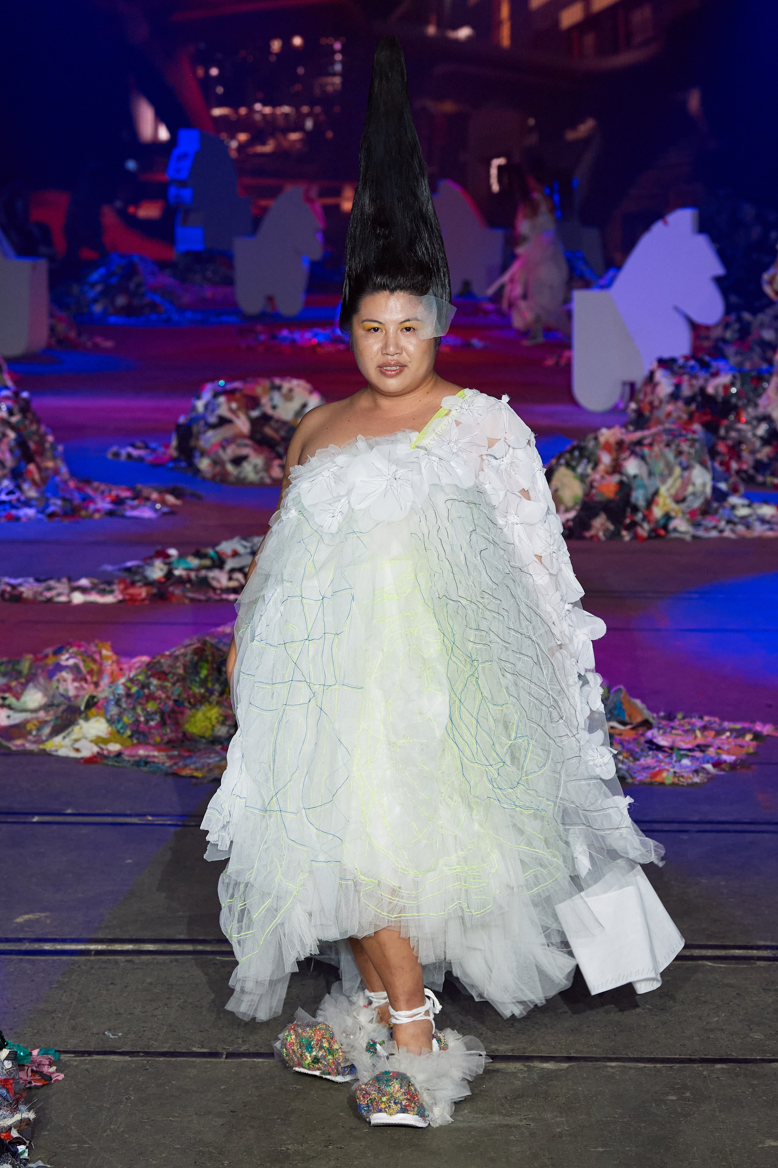 A relaxed white ruffled off-shoulder dress made of tulle, creating a whimsical silhouette.