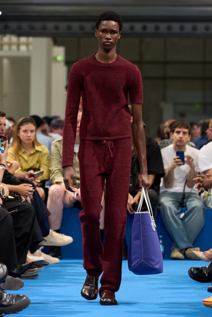 A fitted burgundy knit short-sleeve sweater paired with high-waisted straight-leg pants.