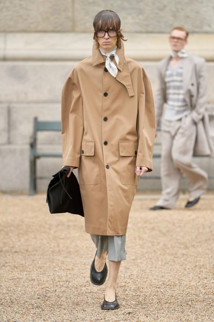 An oversized brown cotton coat with long sleeves and a collared design, featuring button details.