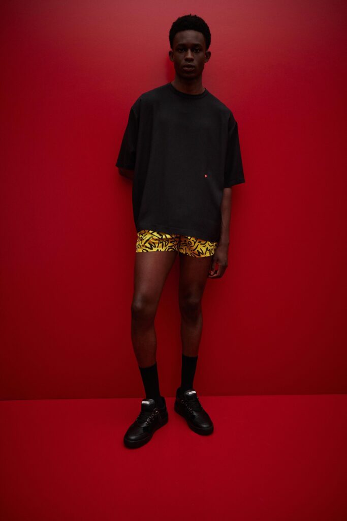 A relaxed black t-shirt paired with yellow printed shorts, perfect for a casual look.